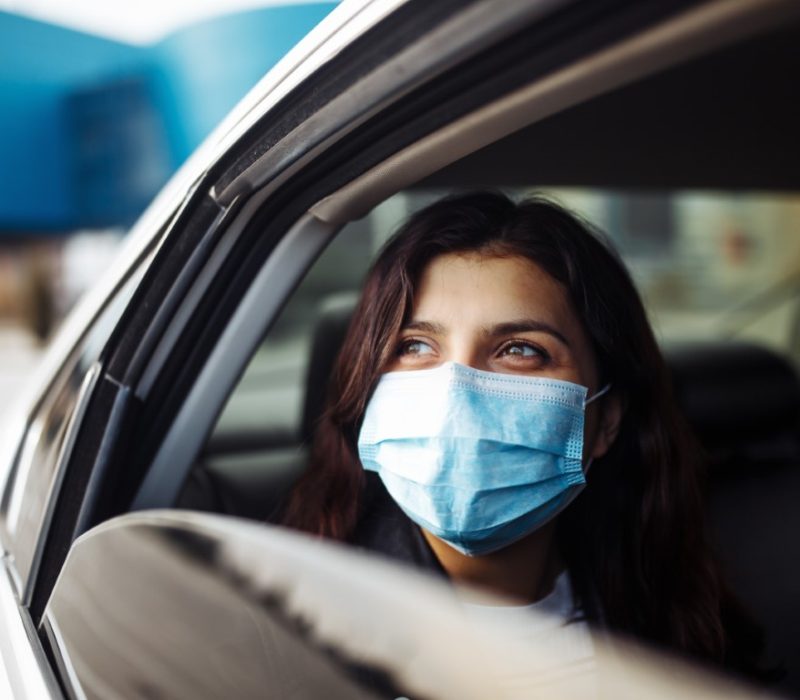 A,Woman,Wearing,A,Medical,Sterile,Mask,In,A,Taxi